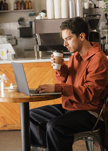 Un tipo trabajando y tomando café