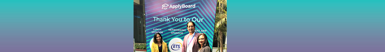 Three people standing in front of ETS ApplyBoard sign
